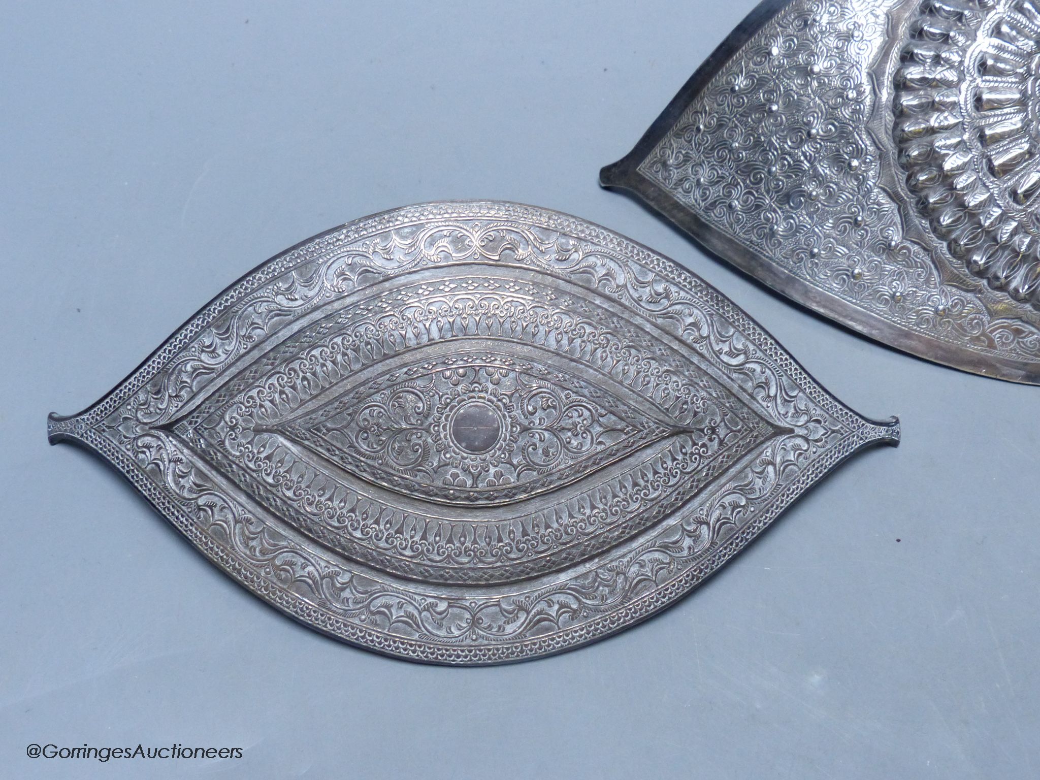 A Chinese Straits large white metal belt buckle, of curved navette form and a similar smaller buckle, L 24.5cm & 20.5cm